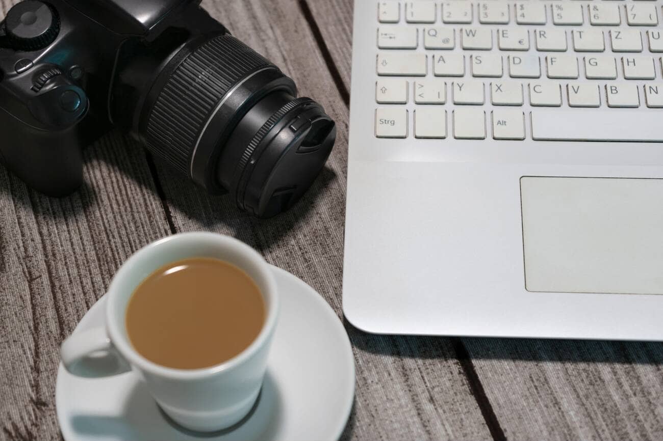 Top view photographer workspace desk ,with a camera , laptop and a coffee cup